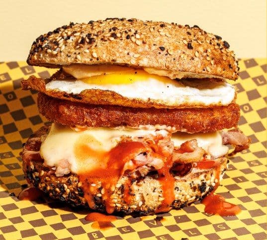 Everything bagel breakfast sandwich stacked with egg and hash brown