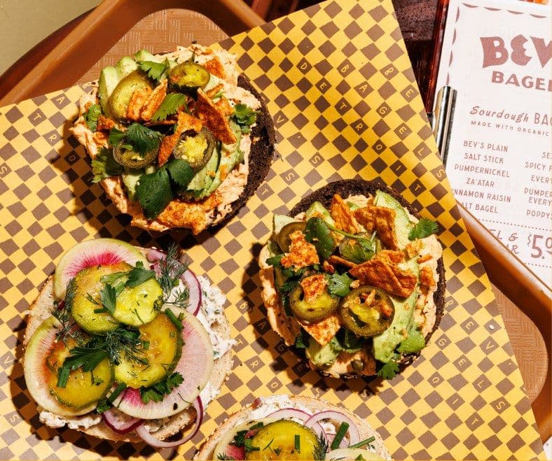 Open-faced bagels topped with schmears, pickles, and jalapeños